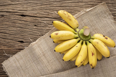 Tasty fresh yellow ripe banana on rustic natural wood texture background with copy space for text
