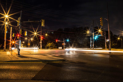 Light trails on road against sky at night