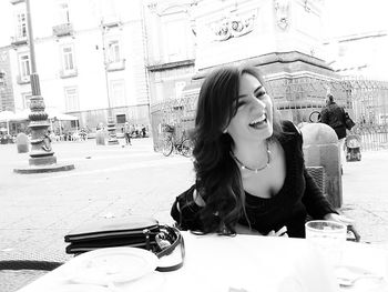 Young woman sitting at sidewalk cafe