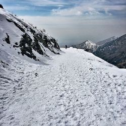 Snowcapped mountain against cloudy sky