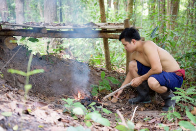 High angle view of shirtless boy sitting on land