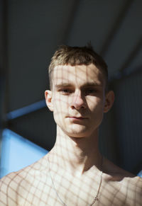 Portrait of young man standing by window