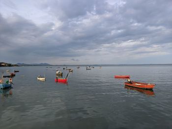 Fishing boats in sea against sky