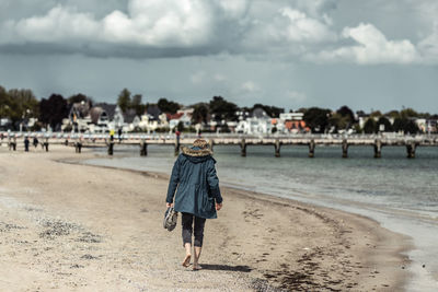 Rear view of woman walking at beach