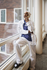 Young female doctor talking on phone at work