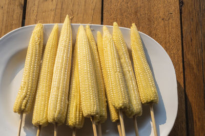 Baby corn on skewers in a white plate