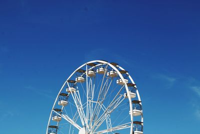 Low angle view of ferris wheel against blue sky