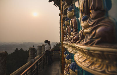 People at temple against sky