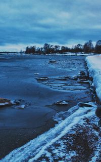 Scenic view of lake against sky during winter