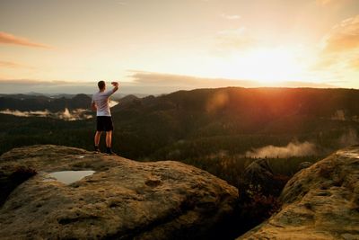 Runner in target gesture triumph with hands in air. crazy man in black pants and  sweaty t-shirt