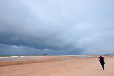 Man standing on beach against sky