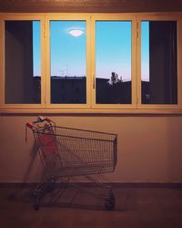 Shopping cart inside a building at sunset.