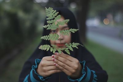 Midsection of woman holding plant