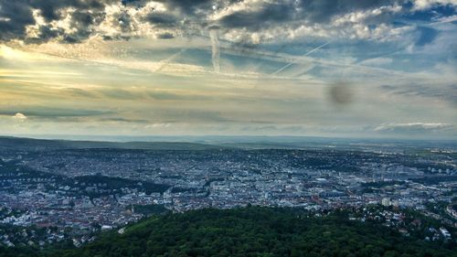 Aerial view of cityscape against cloudy sky