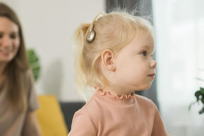 Close-up of mother carrying daughter at home