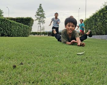 Low angle view of children on grass against trees