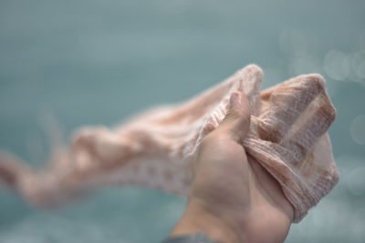 Cropped hand of woman holding fabric outdoors