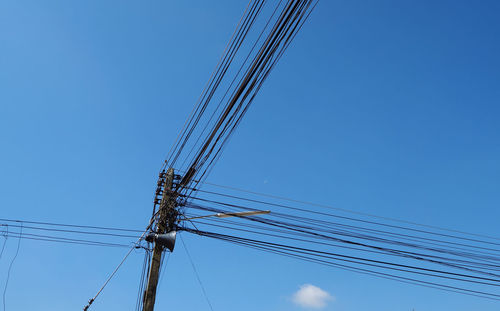 Low angle view of cables against blue sky