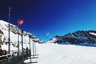 Scenic view of snowcapped mountains against clear blue sky