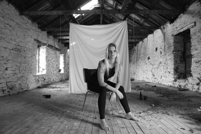 Portrait of woman sitting in abandoned building