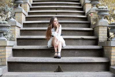 Full length portrait of young woman on staircase