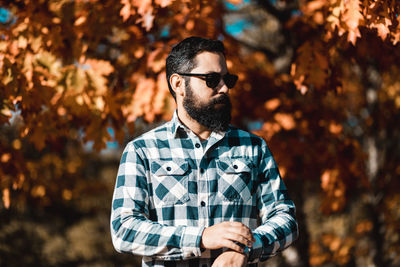 Man wearing sunglasses while standing against trees