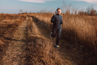 Rear view of man walking on field