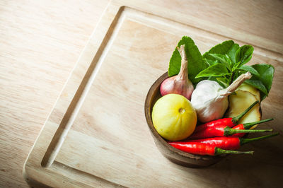 High angle view of food in bowl with cutting board on wooden table