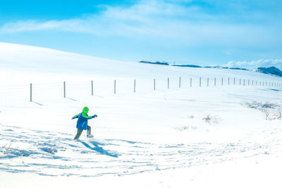 Full length of man on snowcapped field against sky