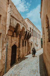 Rear view of woman walking in front of historic building