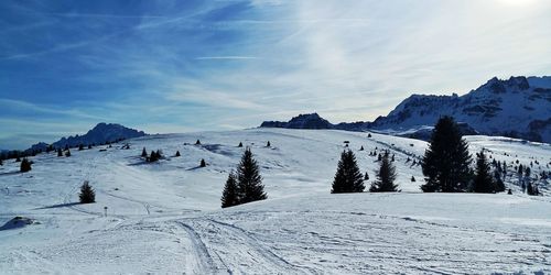 Scenic view of snow covered mountains against blue sky