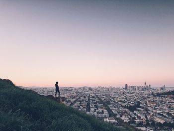 Man standing on landscape against clear sky