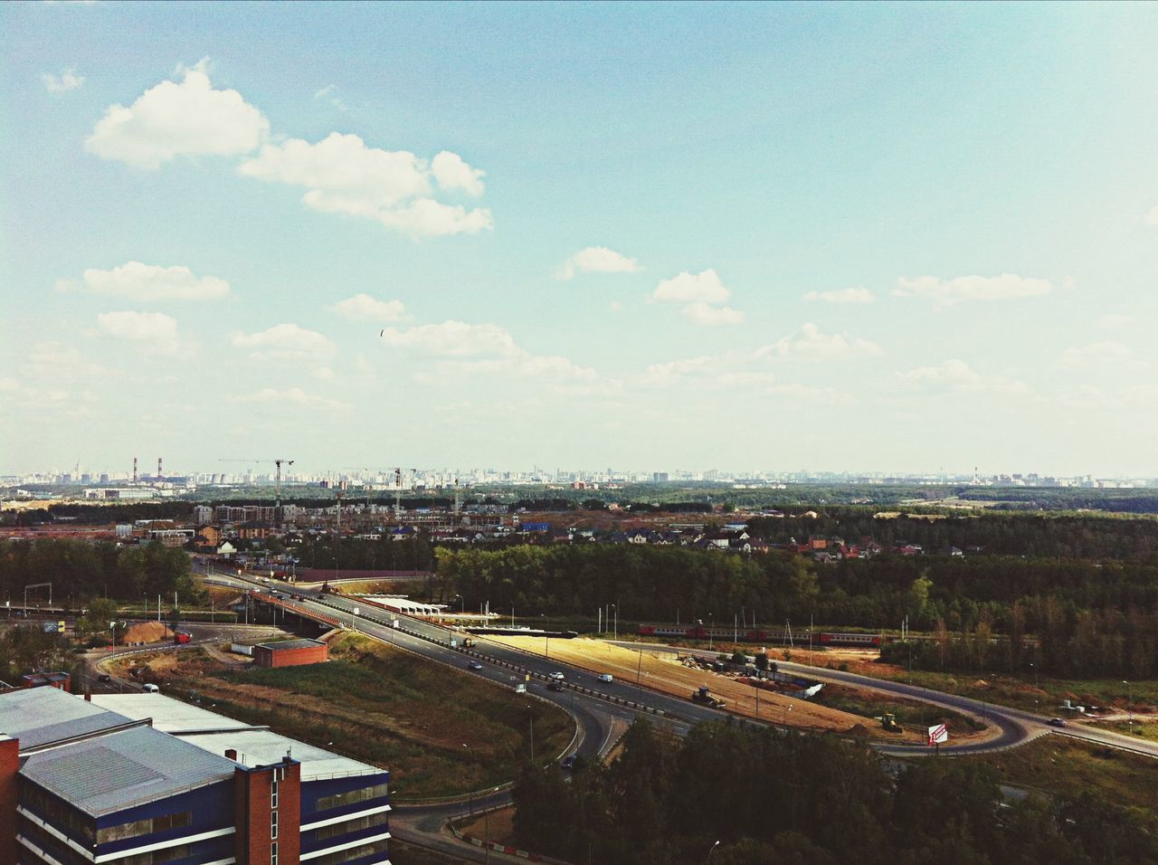 sky, transportation, cloud - sky, building exterior, architecture, built structure, city, mode of transport, land vehicle, road, cloud, cloudy, high angle view, outdoors, tree, car, day, street, nature, landscape