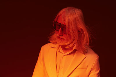 Young woman wearing sunglasses against black background