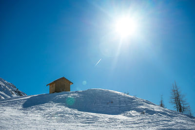 Scenic view of snowcapped mountains against blue sky on sunny day