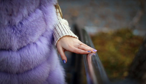 Midsection of woman wearing warm clothing while standing by railing