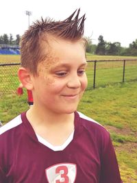 Portrait of boy smiling on field