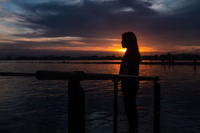 Young teenage girl with long hair at sunset beach looking in the distance. concept of introspection. 