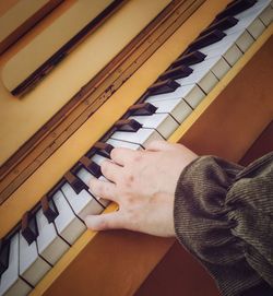 Cropped hand playing piano