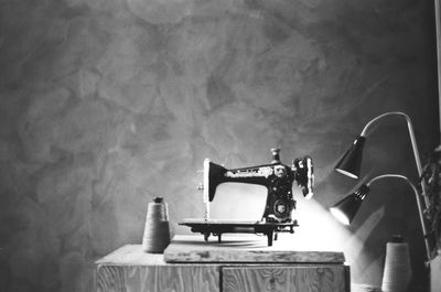 Close-up of sewing machine against wall at home