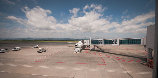 Airplane on airport runway against sky