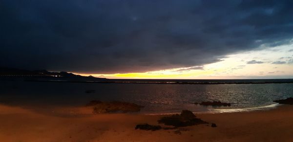 Scenic view of beach against sky during sunset