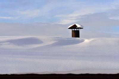 Lifeguard hut on land against sky