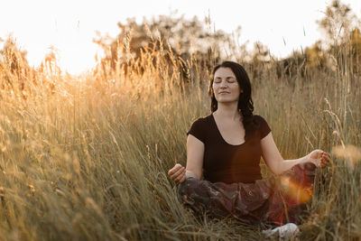 Woman meditating while sitting on grass