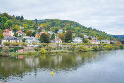 Scenic view of lake by buildings against sky