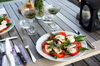 High angle view of tomato with mozzarella cheese in plate on table