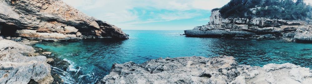 Scenic view of rocks in sea against sky