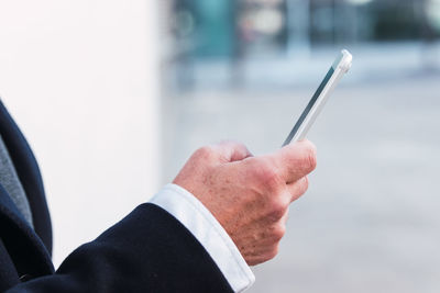 Midsection of businessman using mobile phone