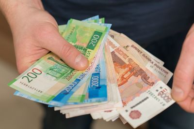 Midsection of man holding paper currencies