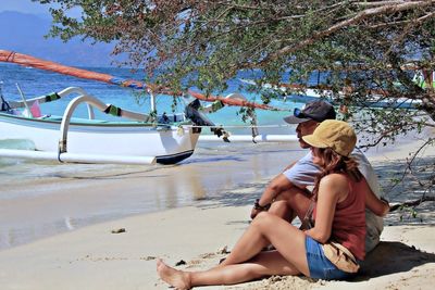 Side view of woman sitting at beach